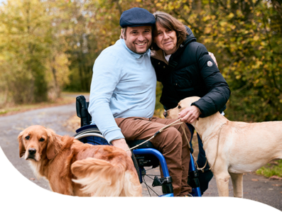 Felix Vos mit Frau im Arm und zwei Assistenzhunden Felix Vos mit Frau im Arm und zwei Assistenzhunden