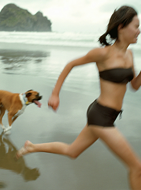 Frau joggt mit ihren Hund am Strand Frau joggt mit ihren Hund am Strand